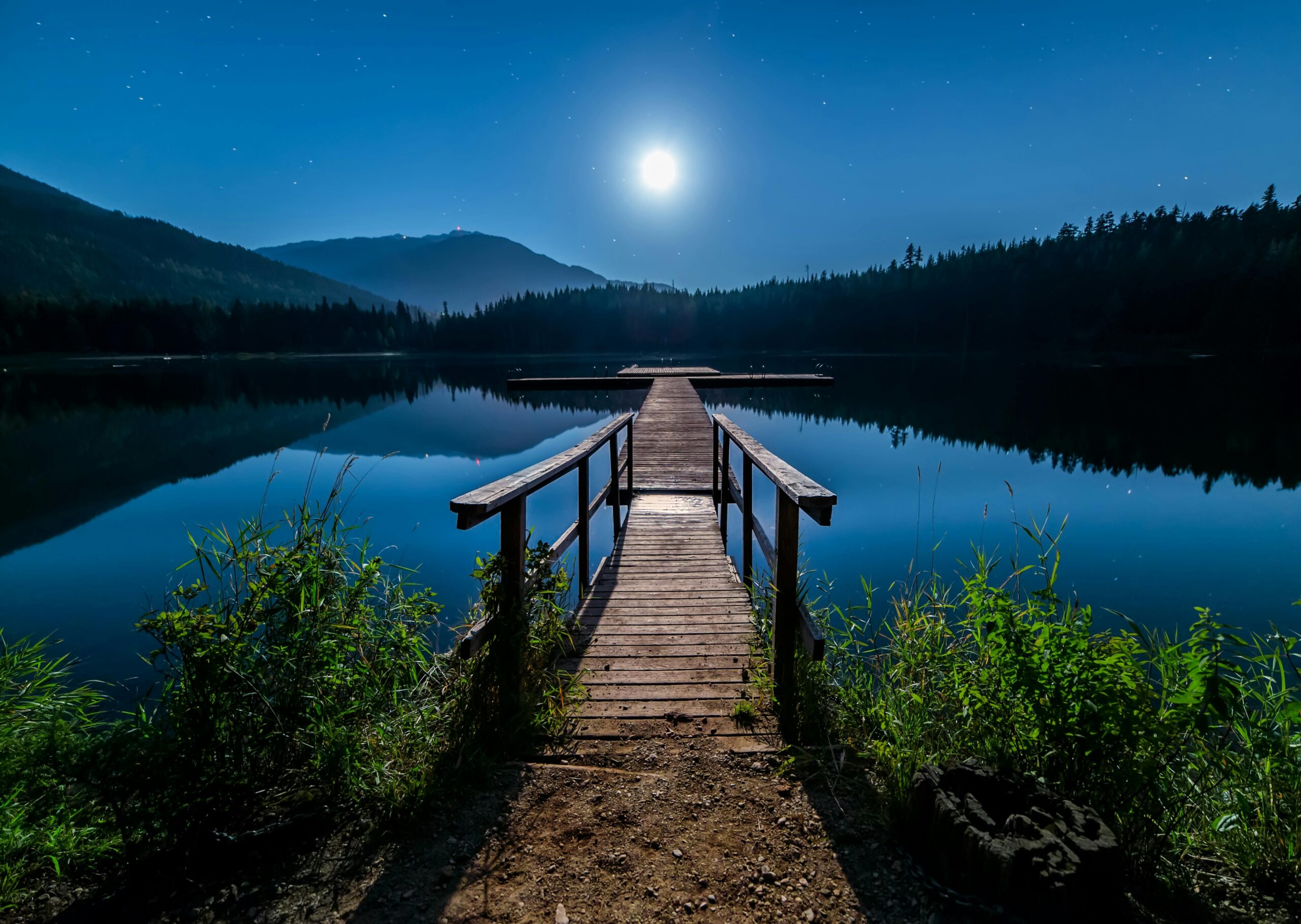 Discover tranquility at a moonlit dock in Whistler, BC, under a starry sky.